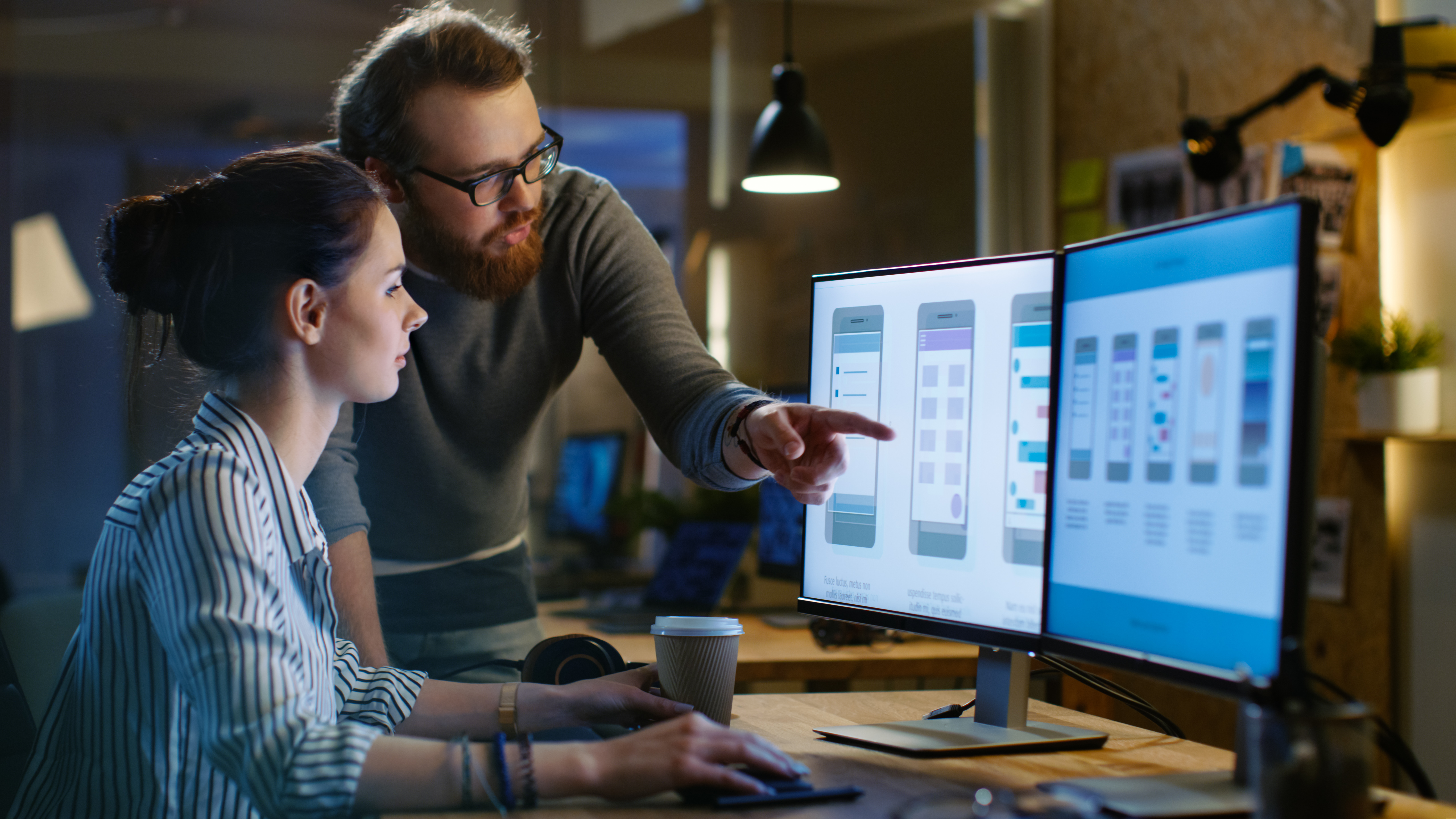 Man helping woman on computer